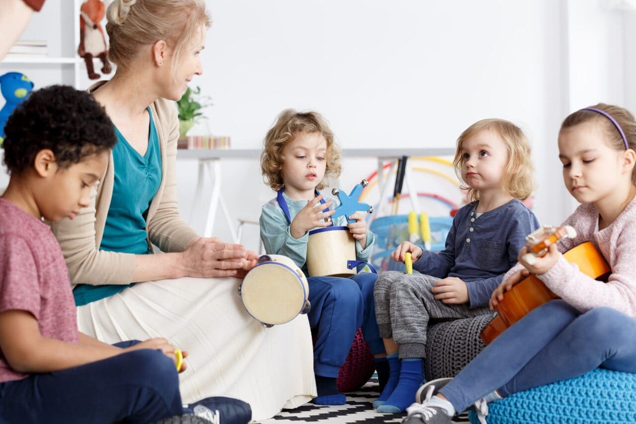 Erzieherin macht mit Kindern Musik